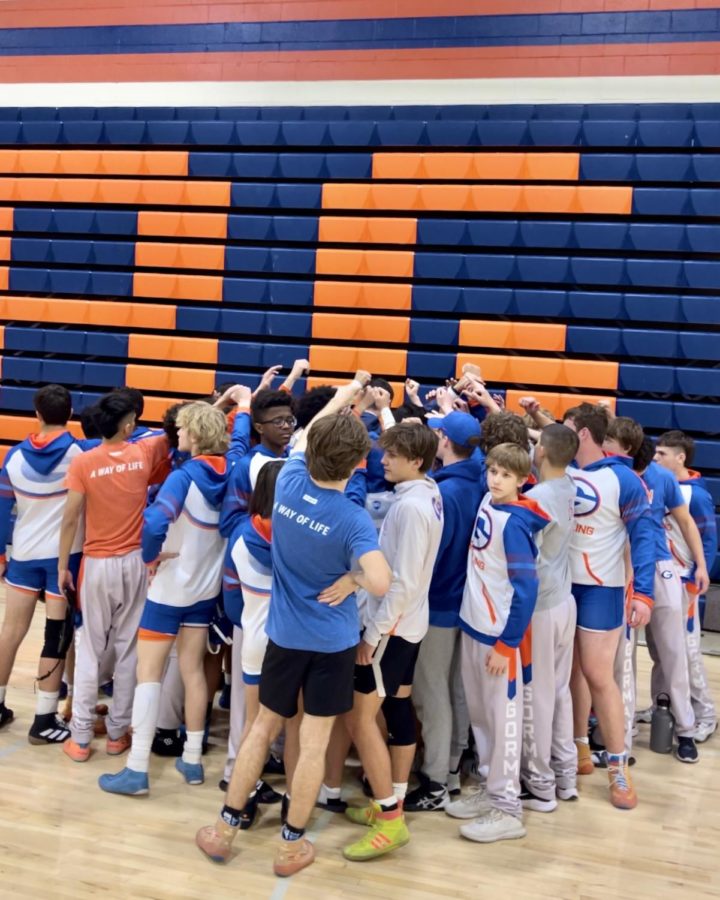 The wrestling team huddles before a meet