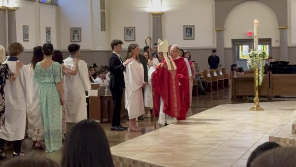 Nora Keating getting confirmed at St. Viator Parish Church with her sponsor Tommy Keating while she was getting confirmed. 