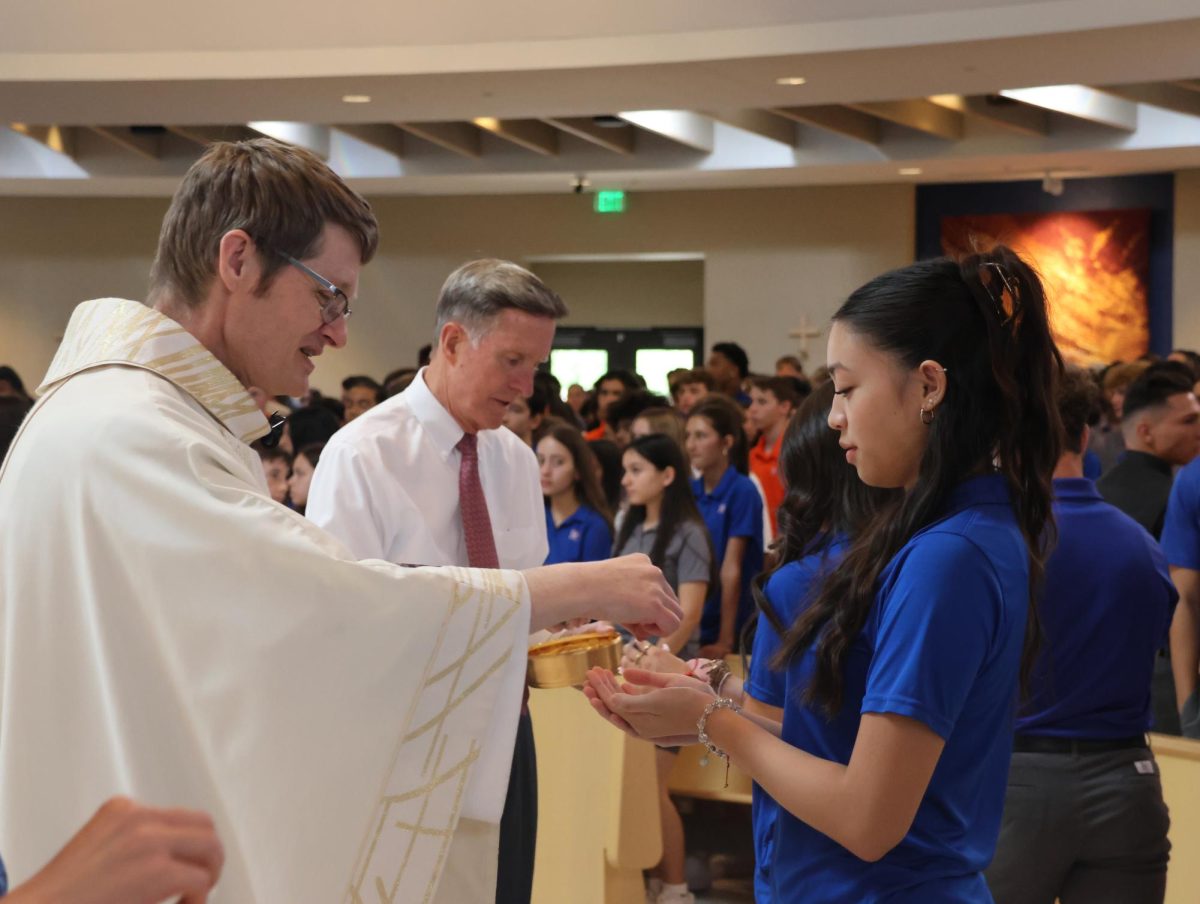 Father Knee giving Communion at the Assumption Mass.