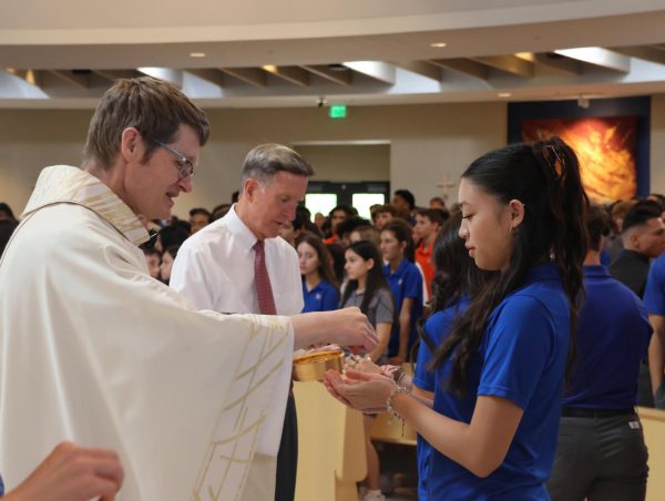 Father Knee giving Communion at the Assumption Mass.