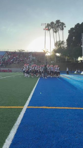 The football team huddled up together on the field. 