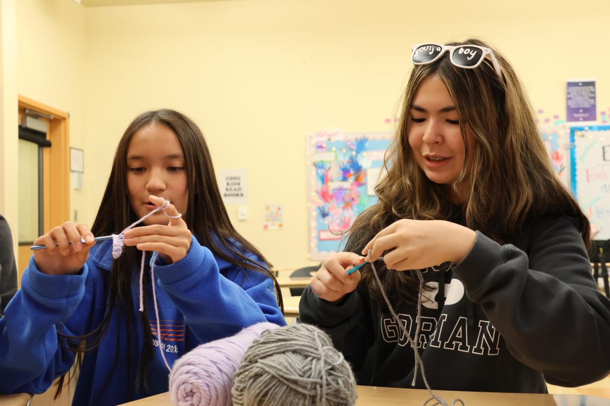 Members of crochet club work on project.