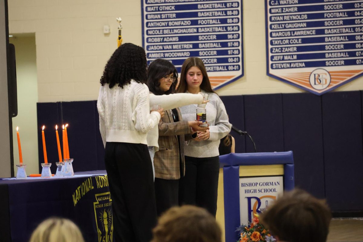 National Art Honor Society at the induction ceremony. When being introduced by Avery Rulis '26, some of the members moved sand together into jars to represent the different people who come together to create art. 