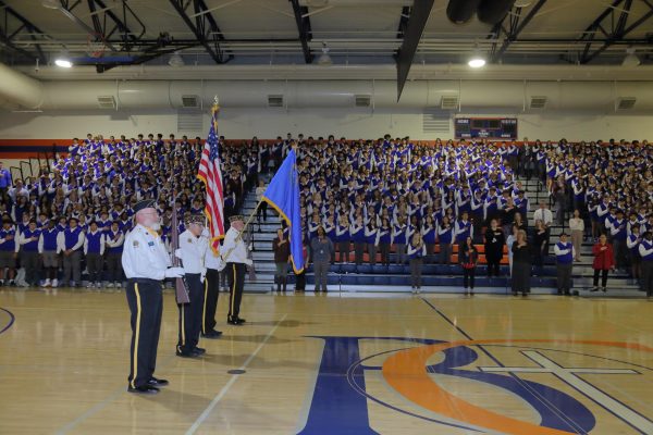 The Color Guard raises the flags and arms in front of the Bishop Gorman student body. 