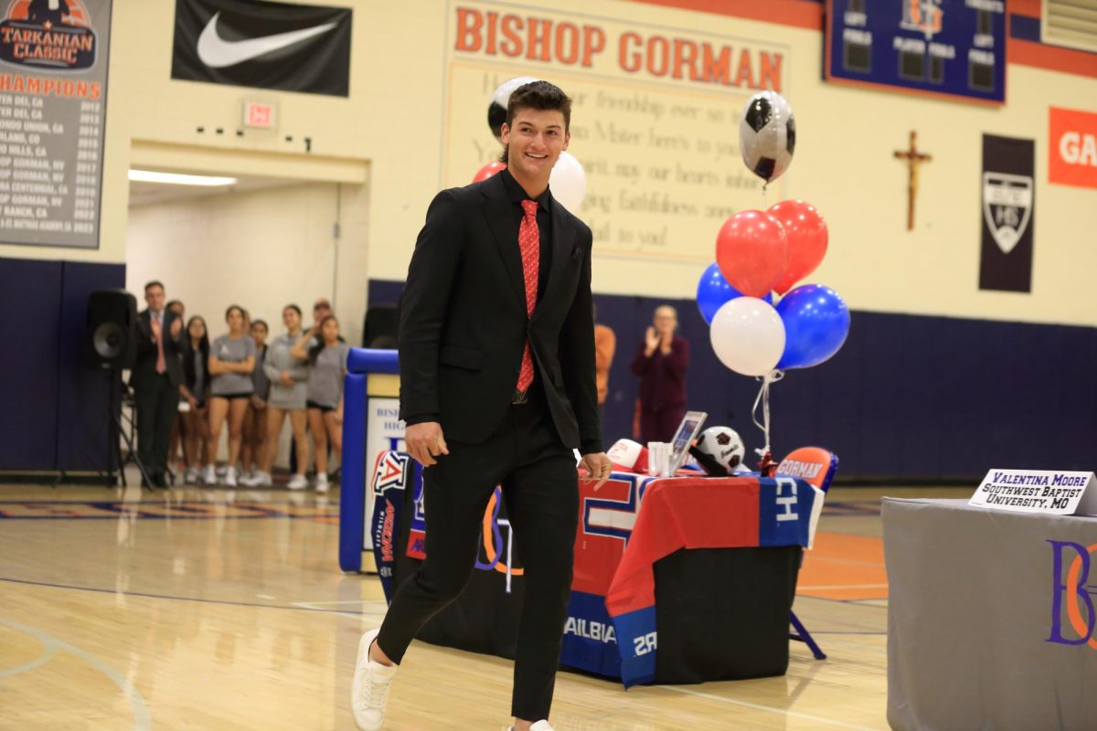 Nolan Eberwein '25 who has committed to USC, walking in to his table to officially sign for the college.