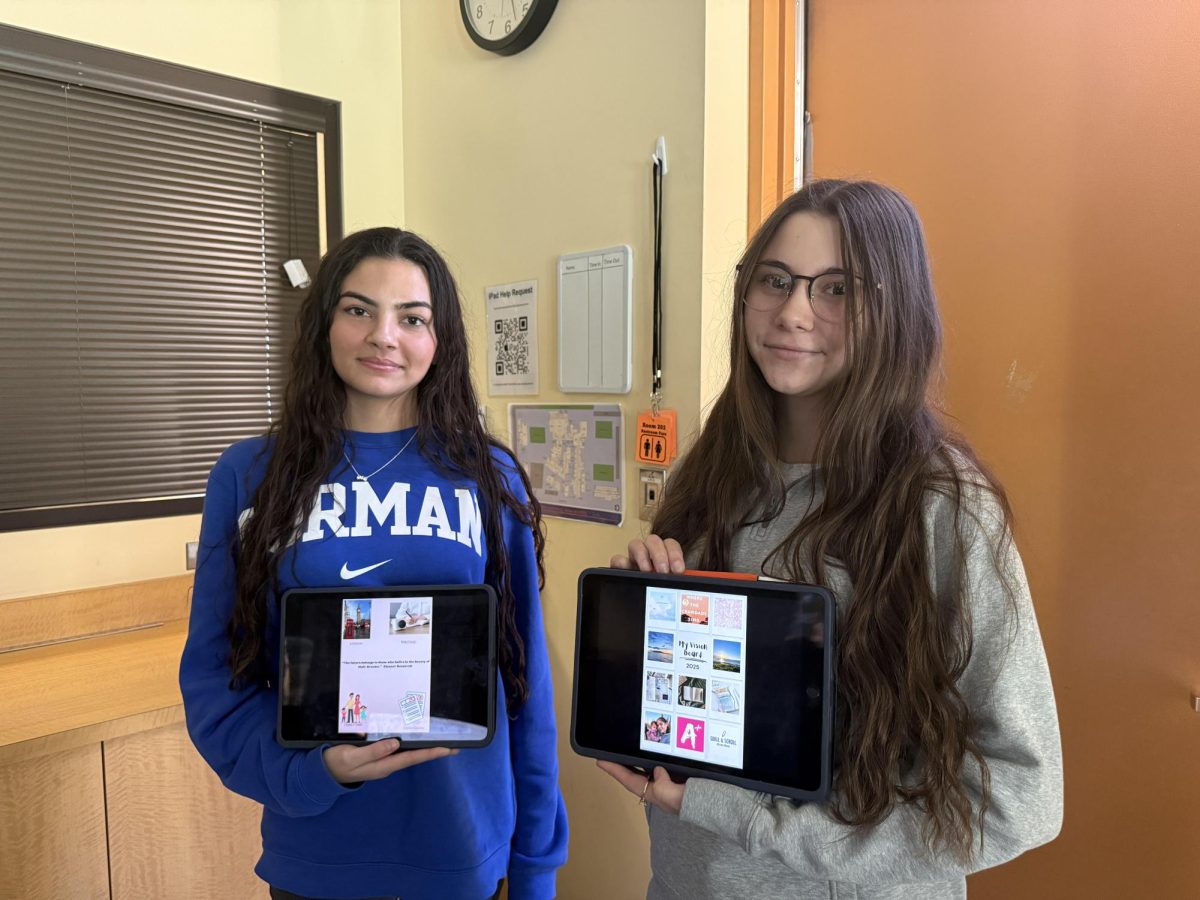 Mya Munoz '26 and Makenzie Medford '26 with the vision boards they made in their theology class. 