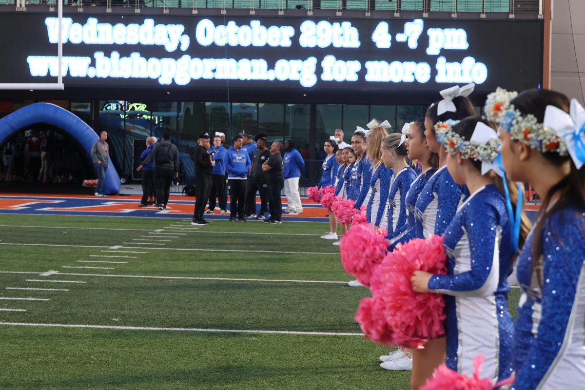 Pom seniors lined up to welcome the football players onto the field.