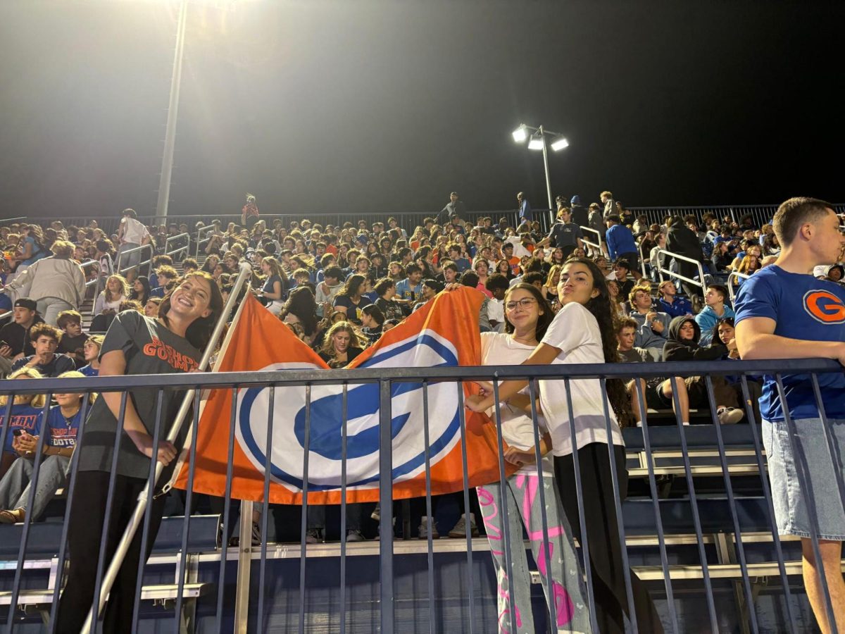 Katelyn Domina '26, Makenzie Medford '26, and Mya Munoz '26 holding up the "G" flag. 