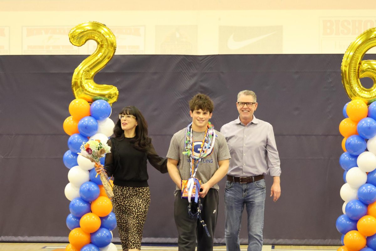 Maddox Frerking '26 walking his senior night with his parents.