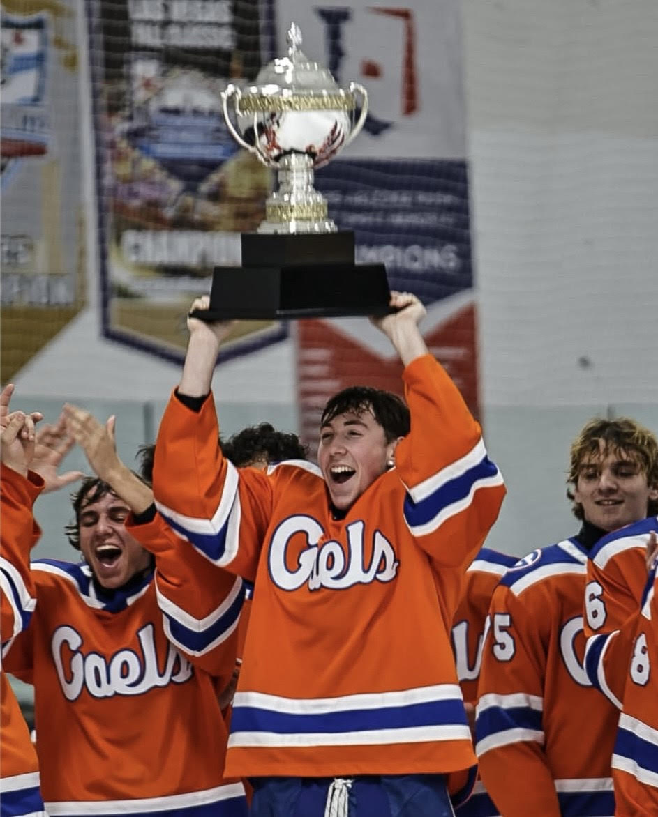 The team hoists the state trophy over their heads. 