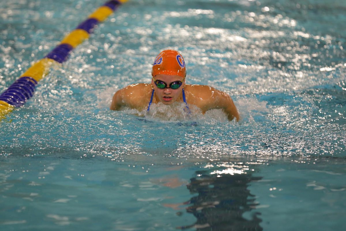 Julianna Herra, '26 swims the butterfly stroke during swim meet.